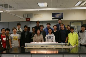 The Science and Engineering Team commemorate the successful construction of their Rubens' tube, a physics apparatus in which flames shoot out of holes drilled into a tube.