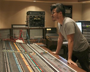 Alumnus Peter Su '03 leans over a soundboard. Courtesy of Peter Su. 